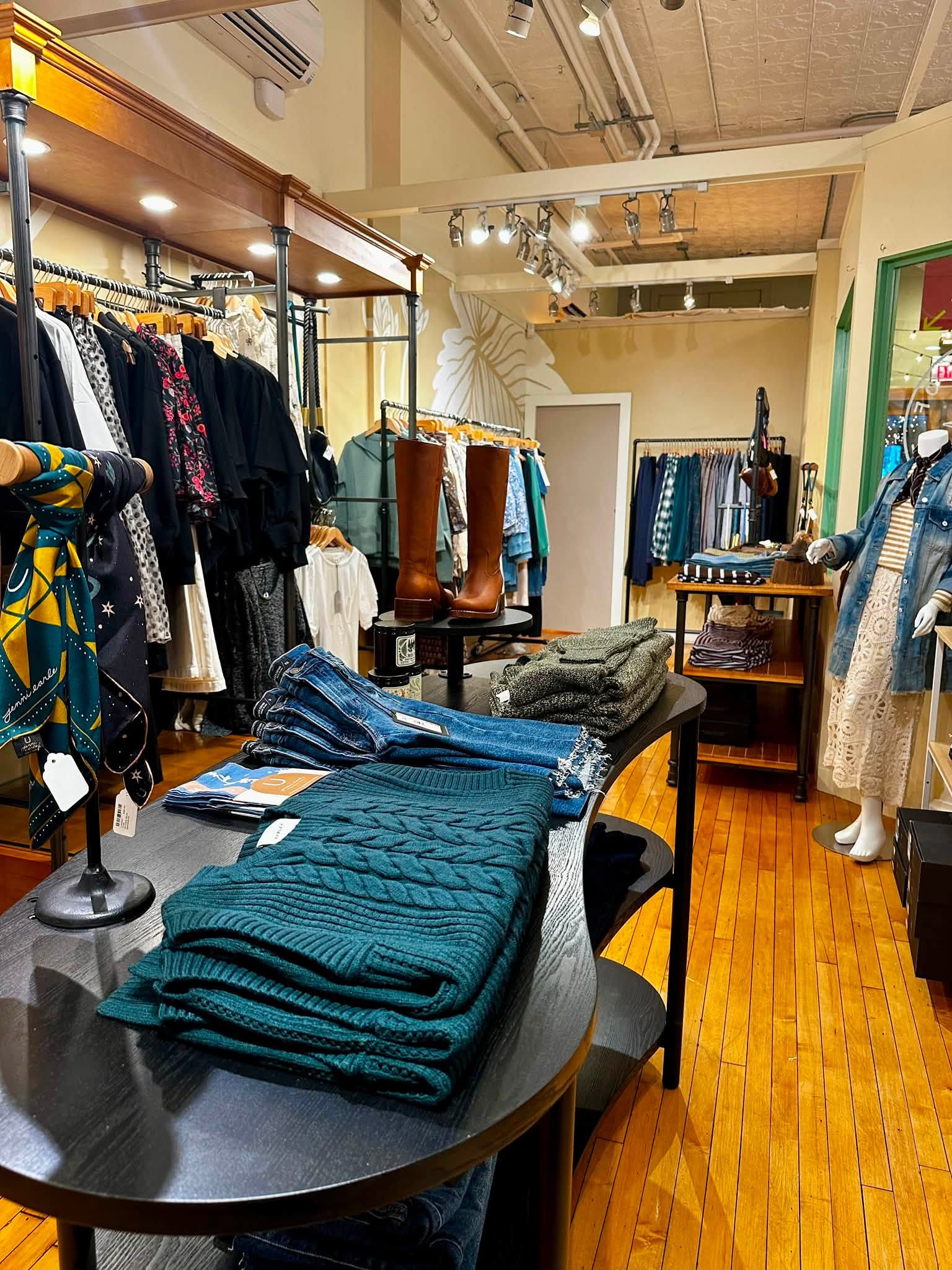 Sweaters, denim, boots, and accessories displayed inside the shop